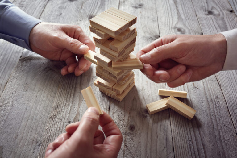 Hands playing a wooden block game on a table